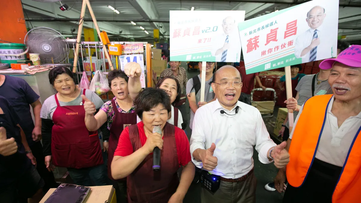 民進黨新北市長參選人蘇貞昌15日清晨赴三重漁市場及果菜市場掃街,向攤商致意,爭取市民支持。更有攤商一秒變身競選戰車的「麥克風手」,帶著大家高喊「衝衝衝」,跟著蘇在市場跑透透。(蘇貞昌辦公室提供)