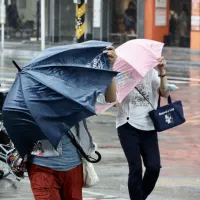 台風30号(チャンパー)の接近で、強い風雨の中を傘を差して歩く人たち。(中央社) 台風30号(チャンパー)の接近で、強い風雨の中を傘を差して歩く人たち。(中央社)