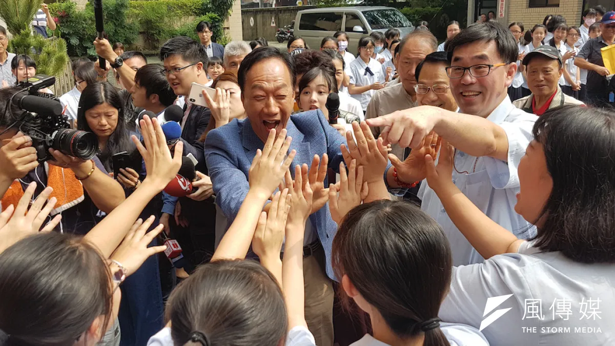 郭台銘走進新竹市私立曙光女中,受到女同學們列隊擊掌的熱情歡迎。(圖/方詠騰攝)