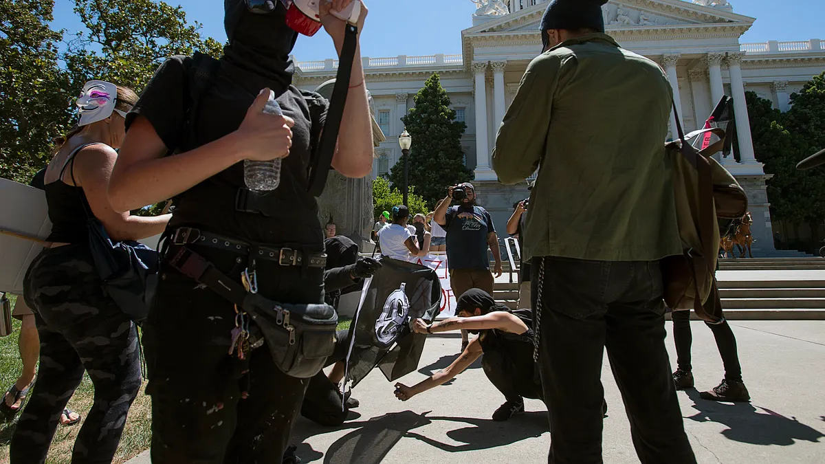 「沙加緬度反法西斯行動」(ANTIFA Sacramento)的成員在加州州議會外高呼反法西斯口號。(美聯社) 「沙加緬度反法西斯行動」(ANTIFA Sacramento)的成員在加州州議會外高呼反法西斯口號。(美聯社)