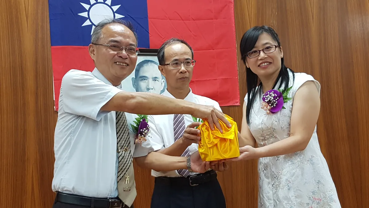 國立新竹高商新卸任校長8日交接,新任校長劉曉雯從卸任校長黃開成手中接過印信。(圖/方詠騰攝)