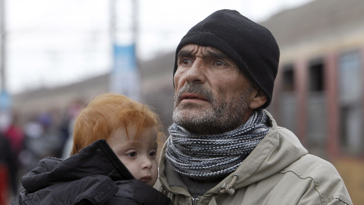 剛抵達馬其頓的難民爸爸手中抱著孩子,望向遠方(美聯社) 剛抵達馬其頓的難民爸爸手中抱著孩子,望向遠方(美聯社)