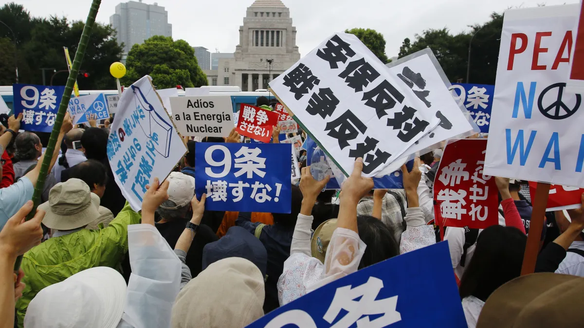 日本民眾冒雨包圍國會,反對新安保法案。(美聯社)