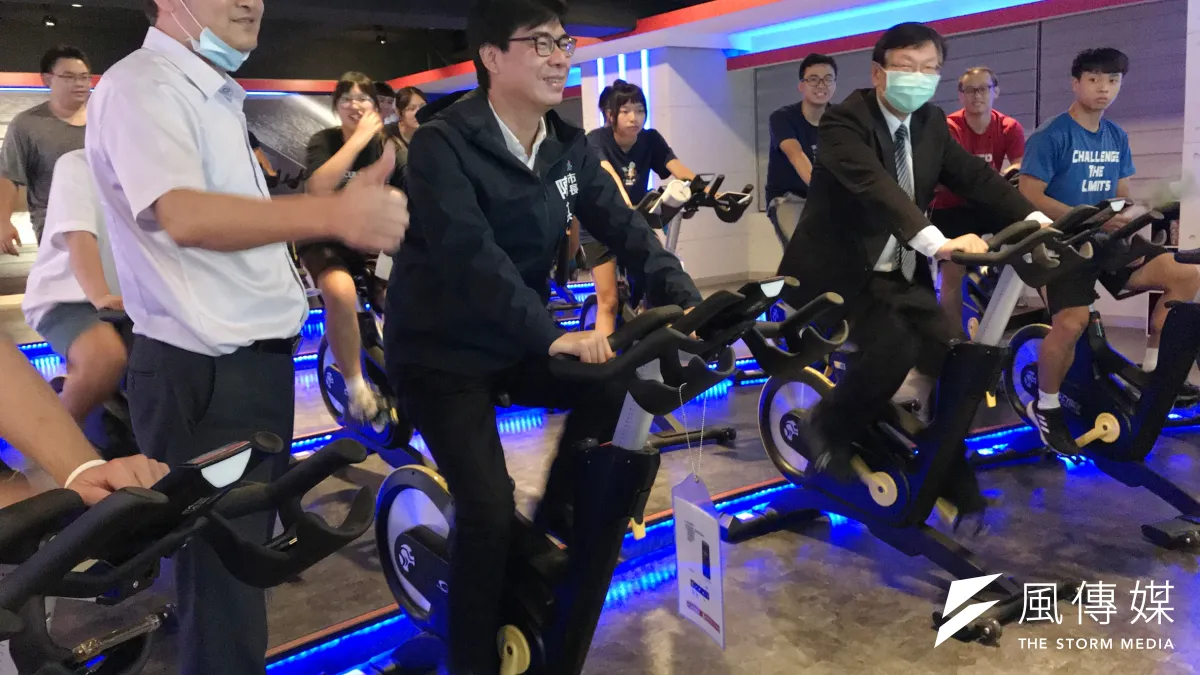 輔英科大校長顧志遠(右二)帶領市長陳其邁(左二)參觀南高雄幸福健康國民運動中心,他看到飛輪教室的健身車採自發電配合超大螢幕,大讚專業並小試身手騎了幾趟。(圖/徐炳文攝)