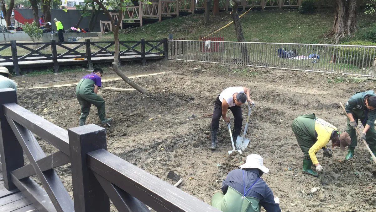 志工與居民清理造成日益陸化的生態池淤泥。(臺北市政府工務局提供)