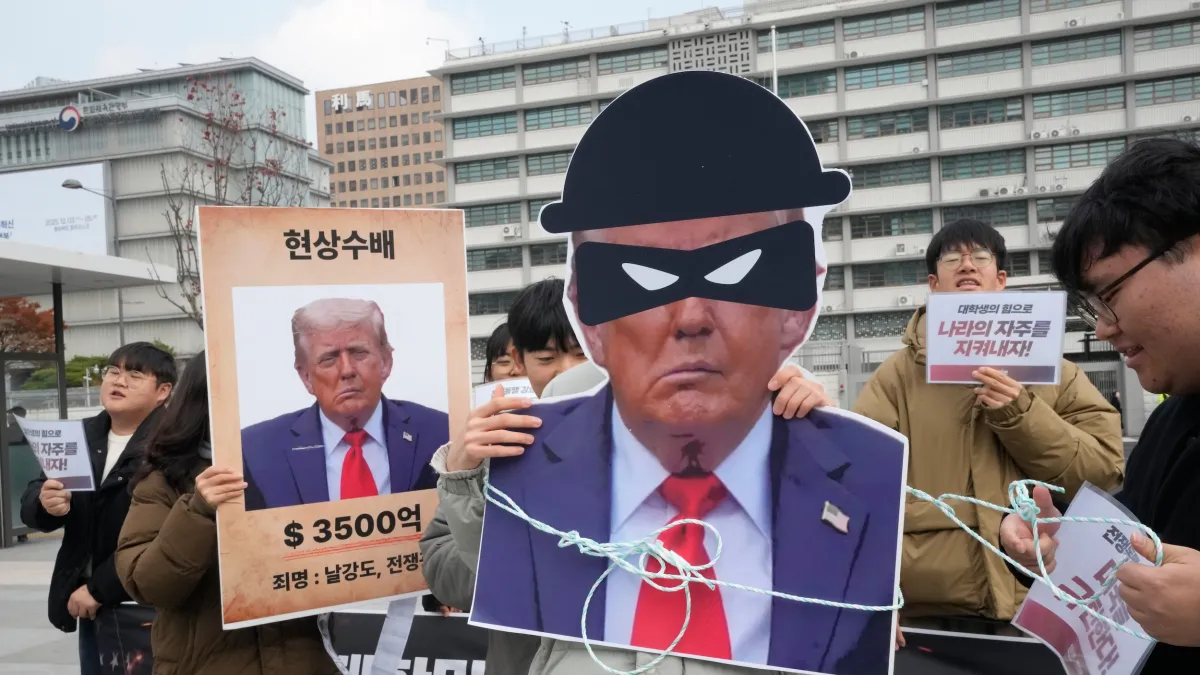 2025年11月20日、ソウルの米国大使館付近で、トランプ米大統領の対韓関税政策に抗議する韓国の大学生ら。左側の横断幕には「WANTED(指名手配)」と書かれている。(写真/AP通信)