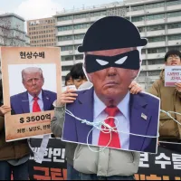 2025年11月20日、ソウルの米国大使館付近で、トランプ米大統領の対韓関税政策に抗議する韓国の大学生ら。左側の横断幕には「WANTED(指名手配)」と書かれている。(写真/AP通信) 2025年11月20日、ソウルの米国大使館付近で、トランプ米大統領の対韓関税政策に抗議する韓国の大学生ら。左側の横断幕には「WANTED(指名手配)」と書かれている。(写真/AP通信)