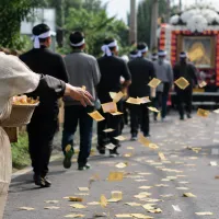 靈車或送葬隊伍緩緩前進,有人手裡拿著一疊紙錢,一邊走、一邊把紙錢撒向道路。(圖/ChatGPT生成圖片) 靈車或送葬隊伍緩緩前進,有人手裡拿著一疊紙錢,一邊走、一邊把紙錢撒向道路。(圖/ChatGPT生成圖片)