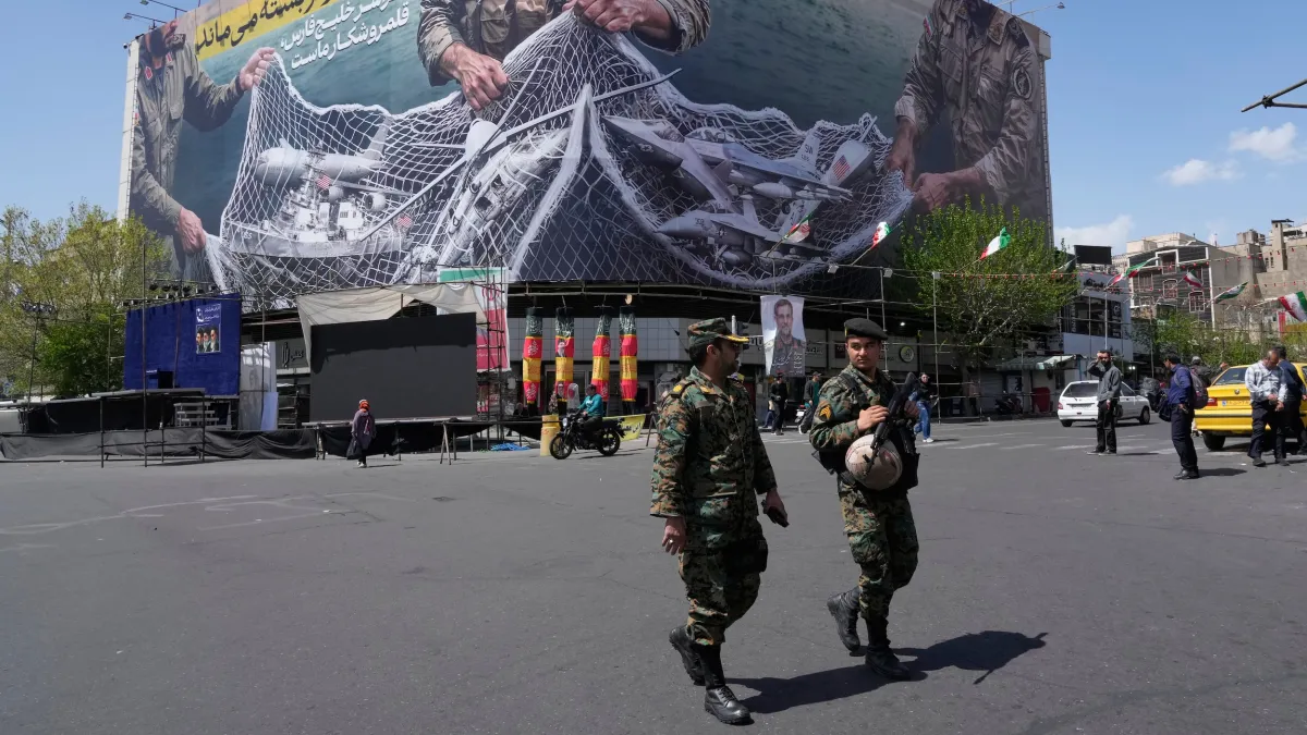 A large anti-American poster displayed at Enqelab-e-Eslami (Islamic Revolution) Square in central Tehran, Iran, on April 5, 2026, depicting a captured American warplane. The slogan, written in Farsi, reads: 'The Strait of Hormuz will remain closed — the e