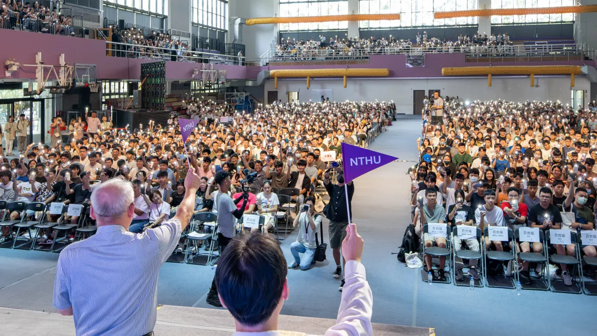 清華大學26日舉辦新生領航營,師長代表高舉清華小旗,新生們也亮起手機手電筒回應。(圖/清華大學提供)