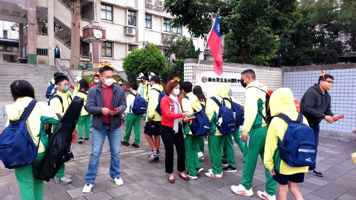 淡水國中開學日同學收到王潔雯校長(中)、家長會長郭啟沐(左)及師長特別製作創意紅包小卡超級開心。(圖/新北市淡水國中提供)