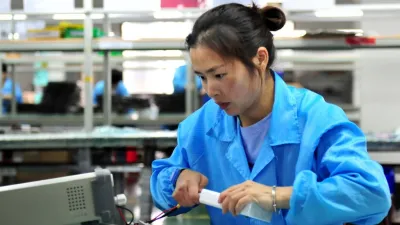 中國女工在生產線上測試鋰電池產品的電源連接。