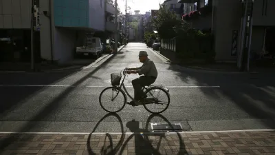 日本老人,日本神戶的一名老人在傍晚騎著腳踏車。(美聯社)