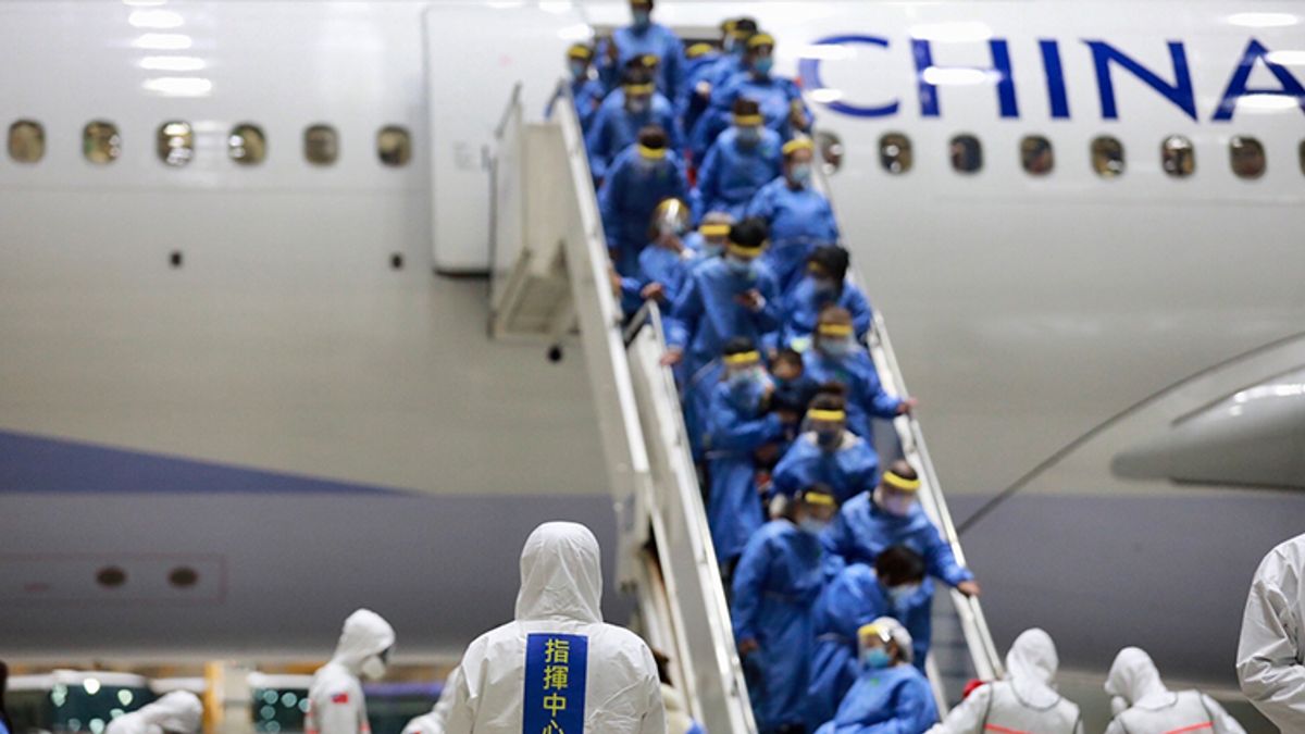 穿著防護衣、配戴口罩的返台國人陸續下機,配合相關檢疫措施。(圖/中央流行疫情指揮中心提供) 穿著防護衣、配戴口罩的返台國人陸續下機,配合相關檢疫措施。(圖/中央流行疫情指揮中心提供)