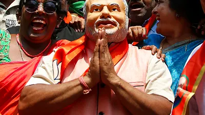 2018年5月15日,印度卡納塔克邦議會選舉之後,民眾頭戴印度總理莫迪的面具,慶祝印度人民黨取得領先。(AP)