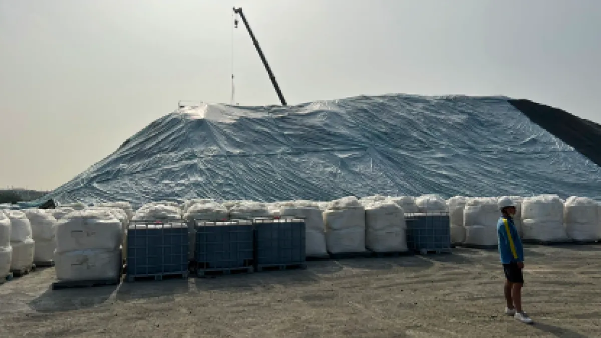 現場堆置污染土方用藍白色帆布覆蓋,下方太空包為生物製劑,添加在執行污染土方生物復育使用。(圖/高市環保局提供)