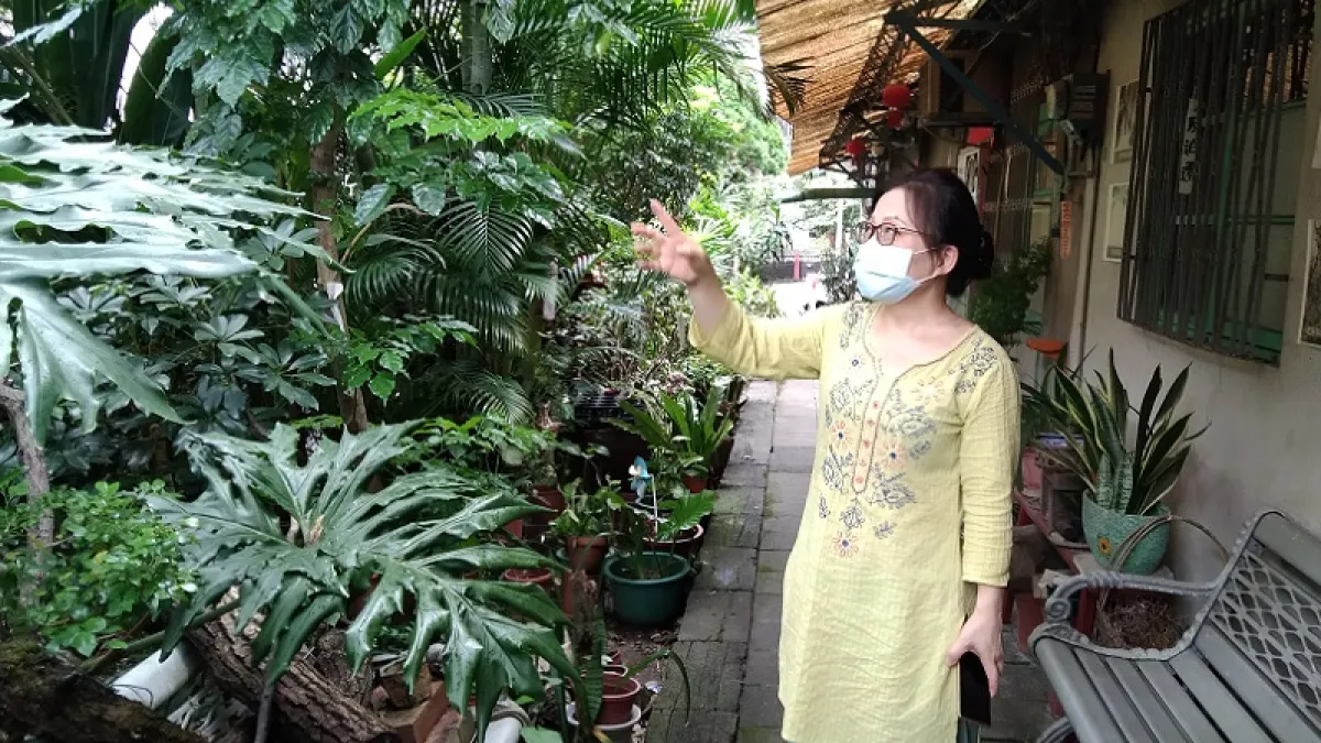 )賴碧珍站在瑠公圳旁的小長屋老宅前,細說一草一木,她答應阿嬤會守住這個老宅,因為這本來就是她們的家。(朱淑娟提供)