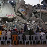 2025年3月1日。ガザ地区南部のラファ(Rafah)で、破壊された住宅と瓦礫に囲まれた長テーブルで食事をするパレスチナ人。(AP) 2025年3月1日。ガザ地区南部のラファ(Rafah)で、破壊された住宅と瓦礫に囲まれた長テーブルで食事をするパレスチナ人。(AP)