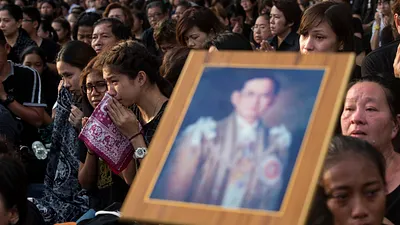 泰國民眾在街頭為駕崩泰王蒲美蓬默禱致哀。(美聯社)