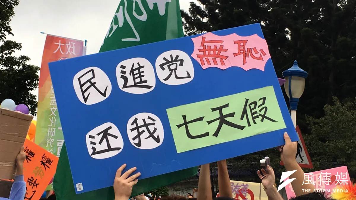 同志大遊行中,有民眾手持「民進黨無恥,還我七天假」標語抗議。(陳耀宗攝)