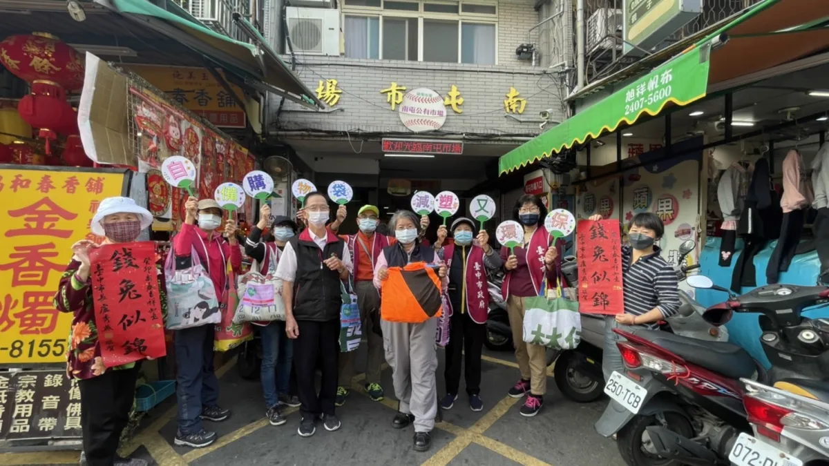自備購物袋減塑又環保,台中市環保局南屯區清潔隊跟男頹市場自治會一起推廣宣導自備購物袋-現場提供150個競選旗幟做成的購物袋很快被索取一空。(圖/台中市政府)