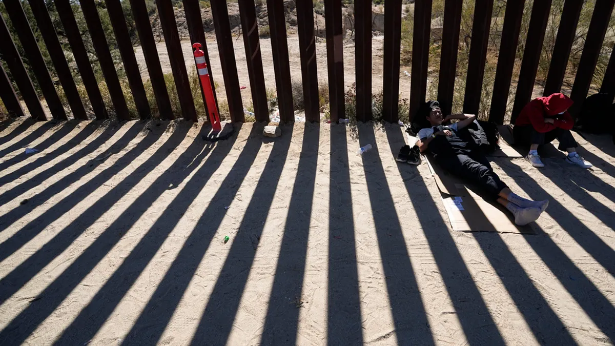 2023年10月24日,美國加州雅庫巴附近,兩名來自中國的男子在越境尋求庇護後,在分隔墨西哥和美國的邊境牆陰影下休息。由於社交媒體上的資訊擴散,巴拿馬達連叢林的偷渡美國路線變得日益熱門。 (美聯社) 2023年10月24日,美國加州雅庫巴附近,兩名來自中國的男子在越境尋求庇護後,在分隔墨西哥和美國的邊境牆陰影下休息。由於社交媒體上的資訊擴散,巴拿馬達連叢林的偷渡美國路線變得日益熱門。 (美聯社)
