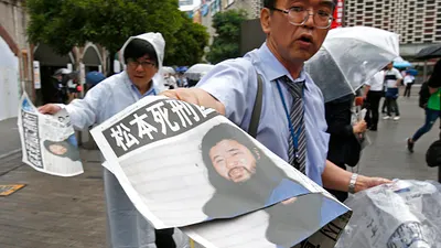 麻原彰晃6日傳出已遭執行死刑完畢,日本媒體在街頭發送快報。(美聯社)
