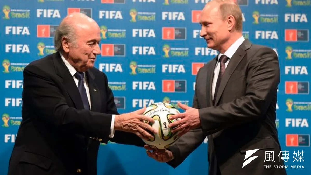 俄羅斯總統普京(右)從FIFA主席布拉特手中接過足球,象徵俄羅斯正式接下2018年世界盃主辦權。(美聯社)