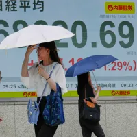 東京の街を行き交う人々と会社員。(AP) 東京の街を行き交う人々と会社員。(AP)