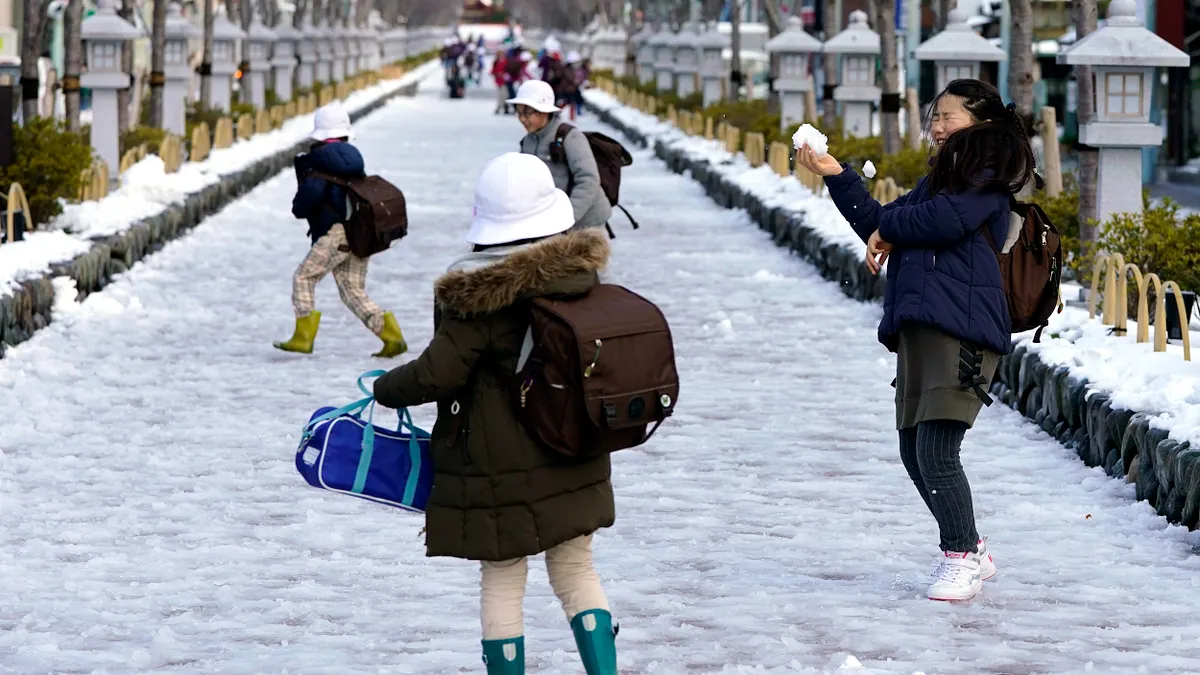 日本大雪,小學生開心在路上玩雪,天再冷,還是著裙裝。(美聯社) 日本大雪,小學生開心在路上玩雪,天再冷,還是著裙裝。(美聯社)