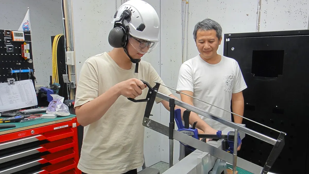 北分署訓練師(右)指導工業控制職類國手陳奕誌(左)練習系統外觀配置線槽切割。(圖/勞動力發展署北分署提供) 北分署訓練師(右)指導工業控制職類國手陳奕誌(左)練習系統外觀配置線槽切割。(圖/勞動力發展署北分署提供)