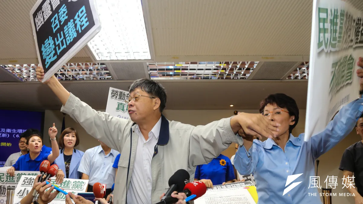 立法院衛環委員會主席台上,國民黨高喊「獨裁政府壓榨勞工 政治黑手撤銷議程」,民進黨立委吳焜裕拿海報擋國民黨,黃昭順阻止。(陳明仁攝)