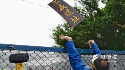 民眾將自製的「不義遺址」紙牌丟入樂生工地。(甘岱民攝)