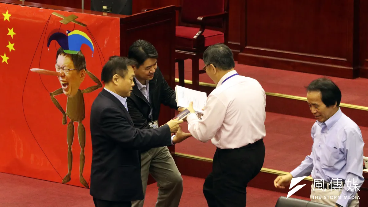 台北市議會13日下午進行市政總質詢,圖為民進黨議員王世堅質詢時,將柯文哲的三本著作還給他,要柯好好回去反省。(蘇仲泓攝)