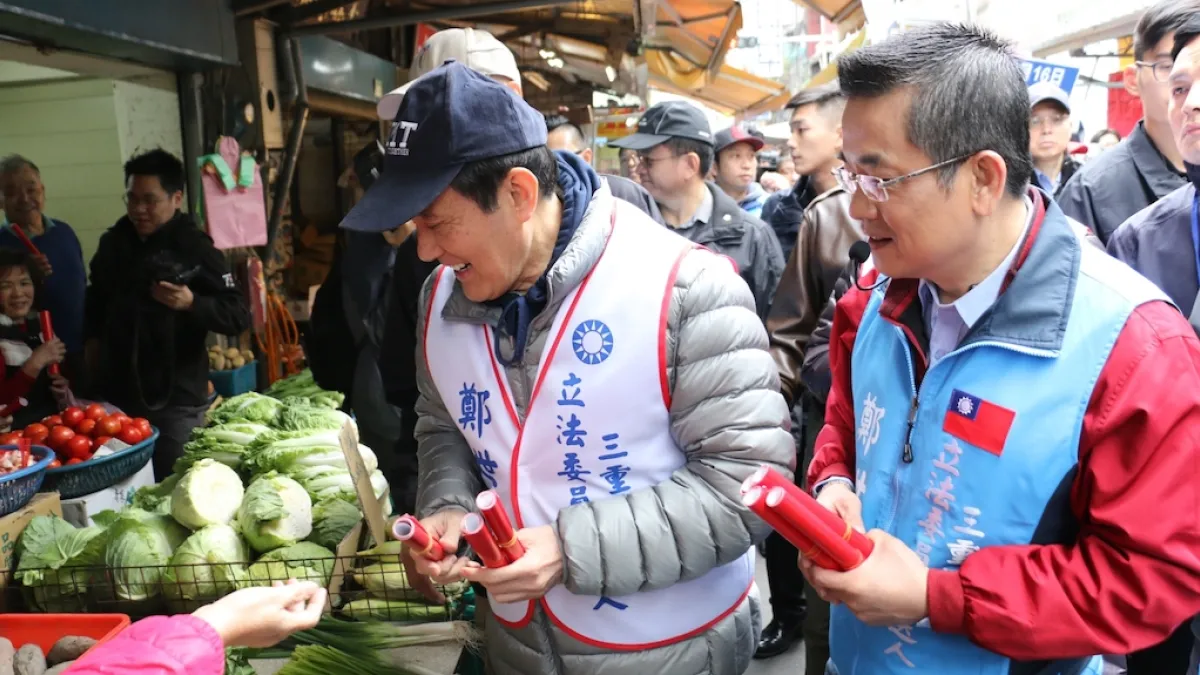 三重區立委補選候選人鄭世維(27)日在前總統馬英九(左)的陪同下,前往大同市場及三和市場掃街拜票,並發送春聯送給民眾,受到民眾熱情包圍。(圖/鄭世維競選辦公室提供)