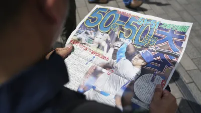 MLB道奇隊球星大谷翔平19日成為MLB第一位「50轟50盜」俱樂部成員,東京街頭許多民眾都在排隊領取快報。(美聯社)
