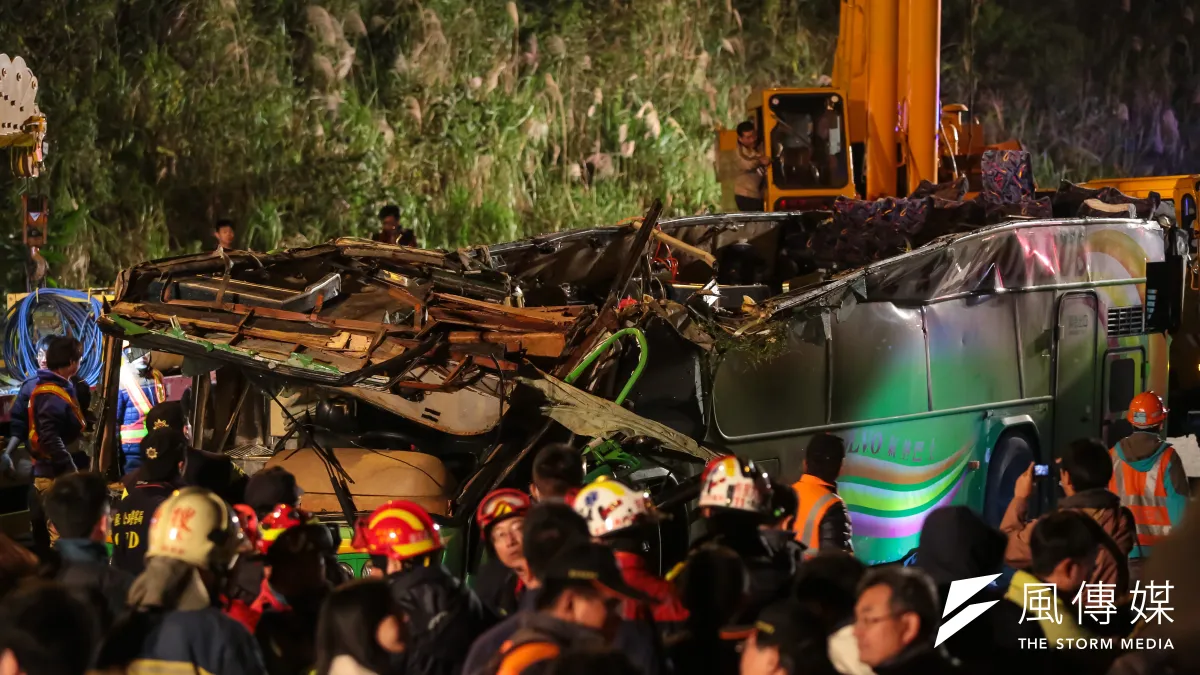 國道5號武陵賞櫻團遊覽車翻覆事故現場,大型吊車將車體吊離邊坡,可見車體上半部幾近磨平。(顏麟宇攝)