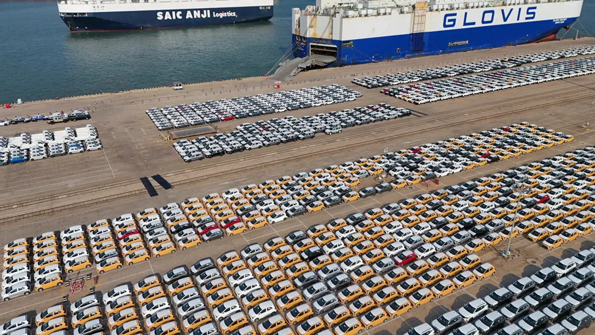 車輛和卡車在中國東部的山東省煙台的一個港口等待運輸出口。(美聯社) 車輛和卡車在中國東部的山東省煙台的一個港口等待運輸出口。(美聯社)