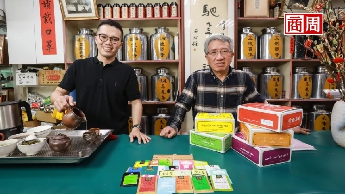 峰圃茶客第4代蔣輝鈞(右)擅技術、第5代蔣亞儒(左)主行銷,小巷店內高掛書法家于右任的「馳名全球」墨寶。(攝影者/陳宗怡,圖/商業周刊)