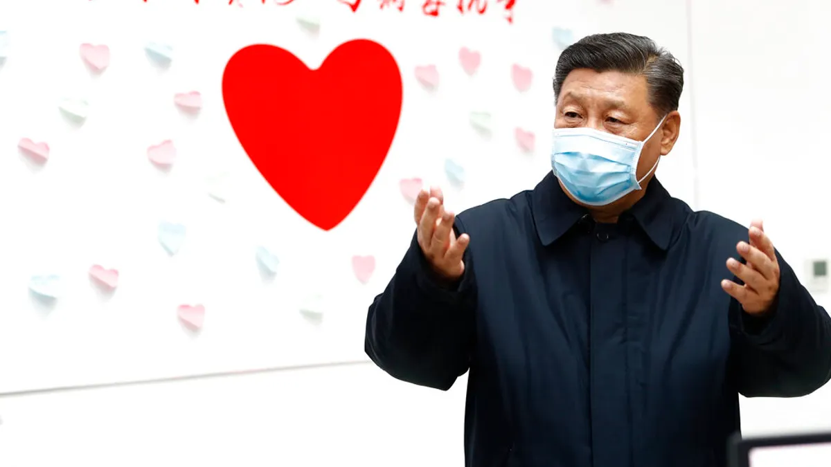 新華社發布一張的習近平照片,背後的牆上還寫著「與時間賽跑,與病毒抗爭」。(美聯社)