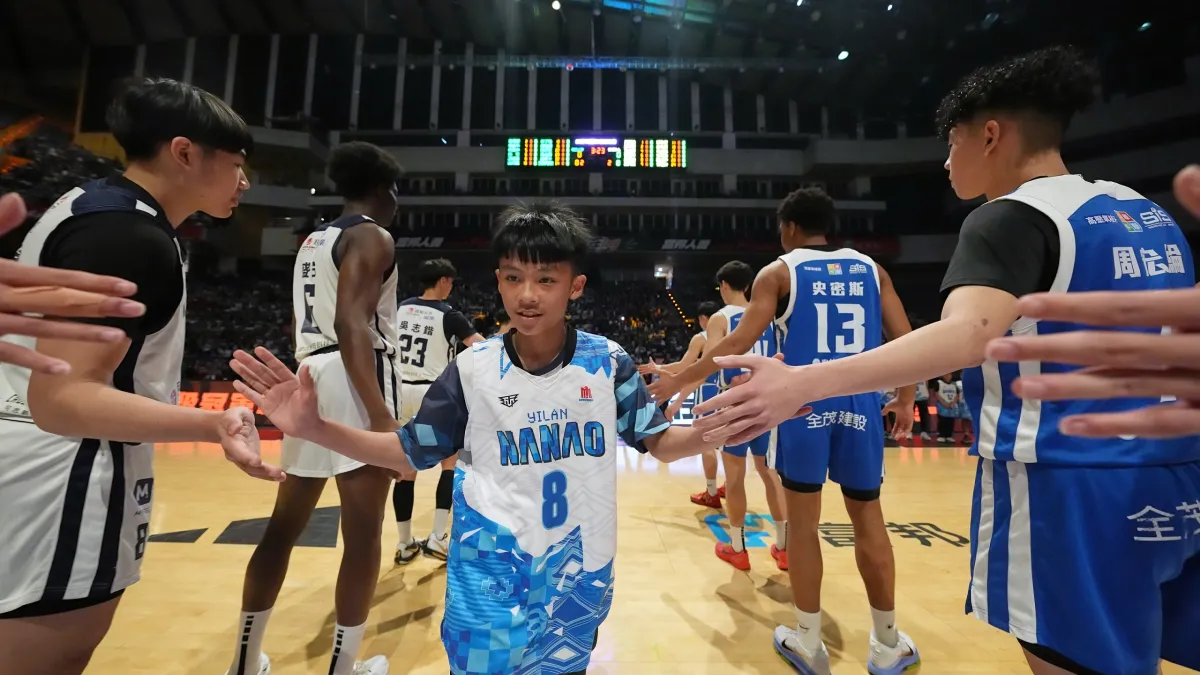 富邦人壽UBA替南澳國小籃球隊圓夢,於男一級冠軍賽前與選手們擊掌互動。(富邦金控提供)
