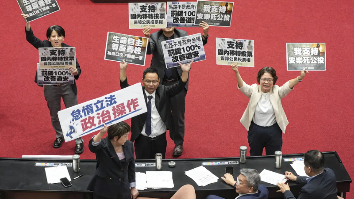 立法院會14日處理公投提案,民眾黨團總召陳清龍(站者中)率黨團立委舉牌表達支持安樂死法制化、交通違規罰鍰專款專用及國內移轉投票等公投訴求,民進黨團書記長范雲(前左)則舉起「怠惰立法、政治操作」手板表達反對。(中央社)