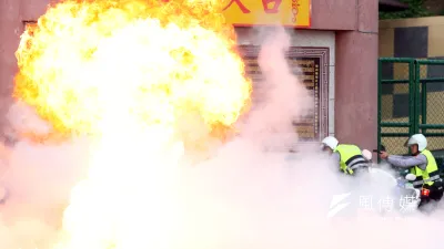 新北市警察局中和分局下午在烘爐地舉行「靖勇專案」實警演練,想定某國海盜組織不滿長期遭該國打擊,遂進入台灣綁架該國來台參與潑水節的代表,並挾持一輛公車。圖為警方遭匪徒以爆裂物攻擊。(蘇仲泓攝)