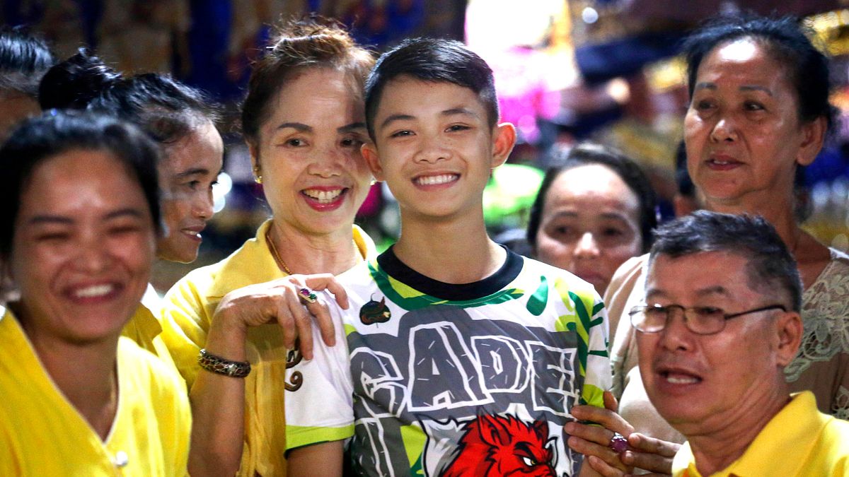 泰國「野豬隊」少年足球隊隊長多姆(中)18日出院,許多親戚歡迎他出院,包括他的嬸嬸塔娜彭(左)(AP) 泰國「野豬隊」少年足球隊隊長多姆(中)18日出院,許多親戚歡迎他出院,包括他的嬸嬸塔娜彭(左)(AP)