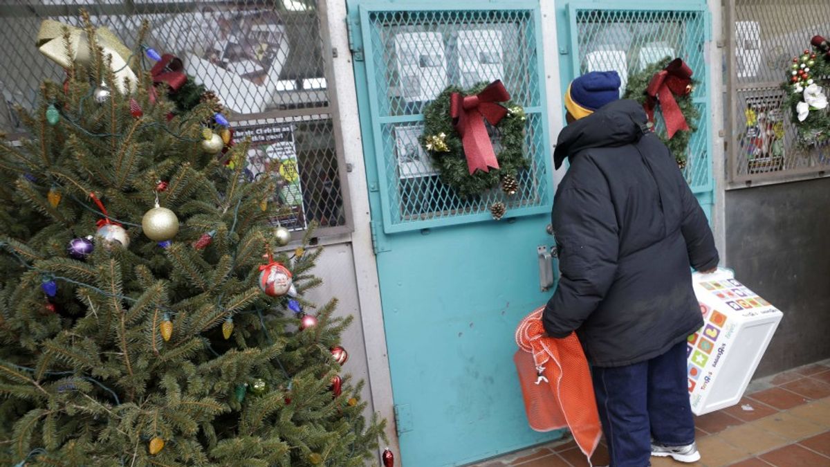 美國一名男子站在「社區行動中心」的門前,這個中心會發送善心民眾捐贈的耶誕禮物與生活用品(AP) 美國一名男子站在「社區行動中心」的門前,這個中心會發送善心民眾捐贈的耶誕禮物與生活用品(AP)