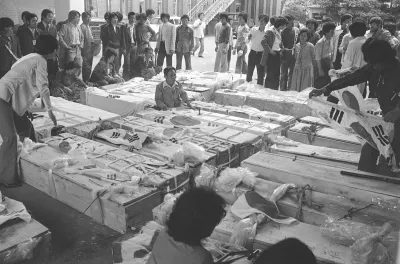 1980年5月23日,南韓光州的民眾聚集在死於光州事件的抗議者棺木旁。(美聯社)
