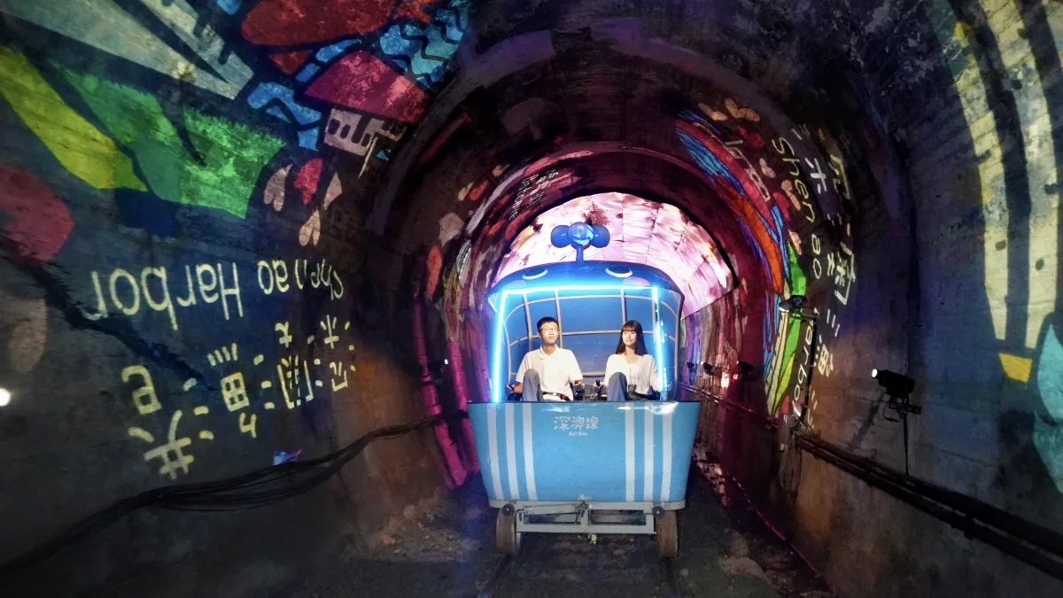 騎進深澳鐵道自行車光隧道,投影燈映照周邊特色景點,彷彿在光影中展開一場深澳小旅行。(圖/新北市觀旅局提供)