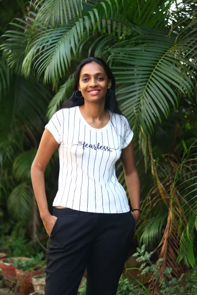 Pallavi standing by a tree with a t-shirt saying 'fearless' on it