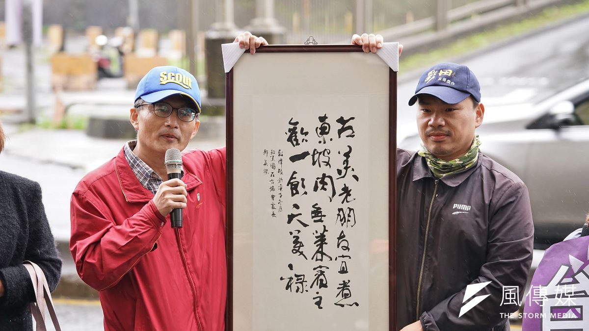 20201221-民間反瘦肉精毒豬聯盟21日於美國在台協會AIT辦事處前召開記者會,醫師蘇偉碩(左)要贈送字畫給AIT處長酈英傑,右為農運人士楊儒門 。(盧逸峰攝) 20201221-民間反瘦肉精毒豬聯盟21日於美國在台協會AIT辦事處前召開記者會,醫師蘇偉碩(左)要贈送字畫給AIT處長酈英傑,右為農運人士楊儒門 。(盧逸峰攝)