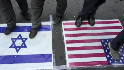 2024年10月8日。在伊朗德黑蘭的巴勒斯坦廣場(Felestin (Palestine) Square)舉行的反以色列集會上,示威者腳踩美國和以色列國旗。(AP)